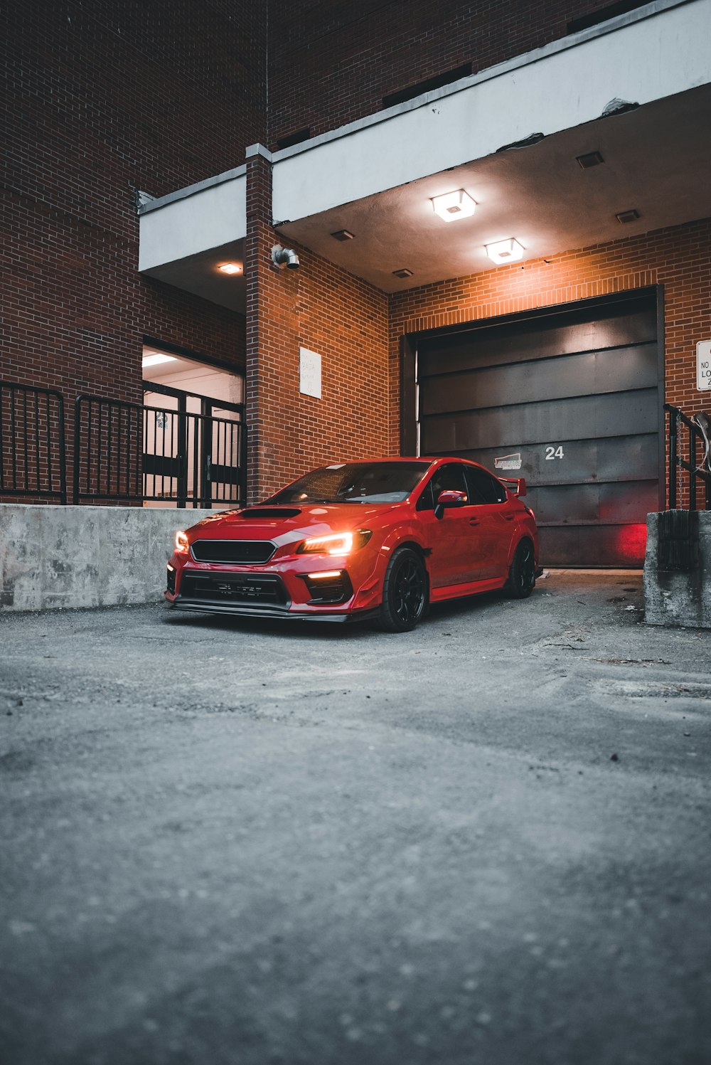 a red car parked in front of a garage