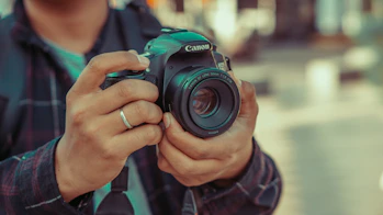 un homme tenant un appareil photo dans ses mains