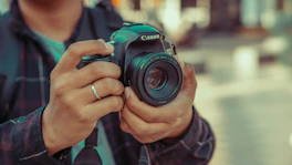 un homme tenant un appareil photo dans ses mains
