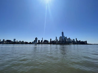 A clear blue sky over Yiwu city with gentle clouds and sunlight reflecting off modern buildings.