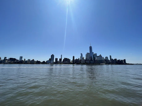 A clear blue sky over Yiwu city with gentle clouds and sunlight reflecting off modern buildings.
