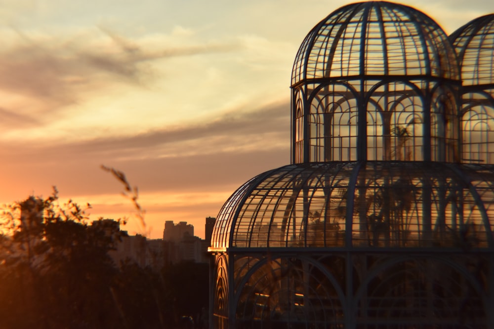 the sun is setting behind a glass building