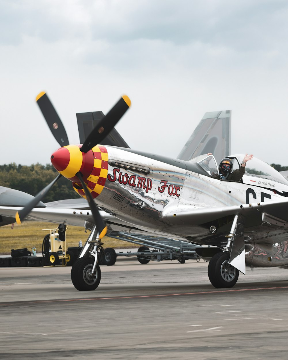 a silver and red plane on a runway