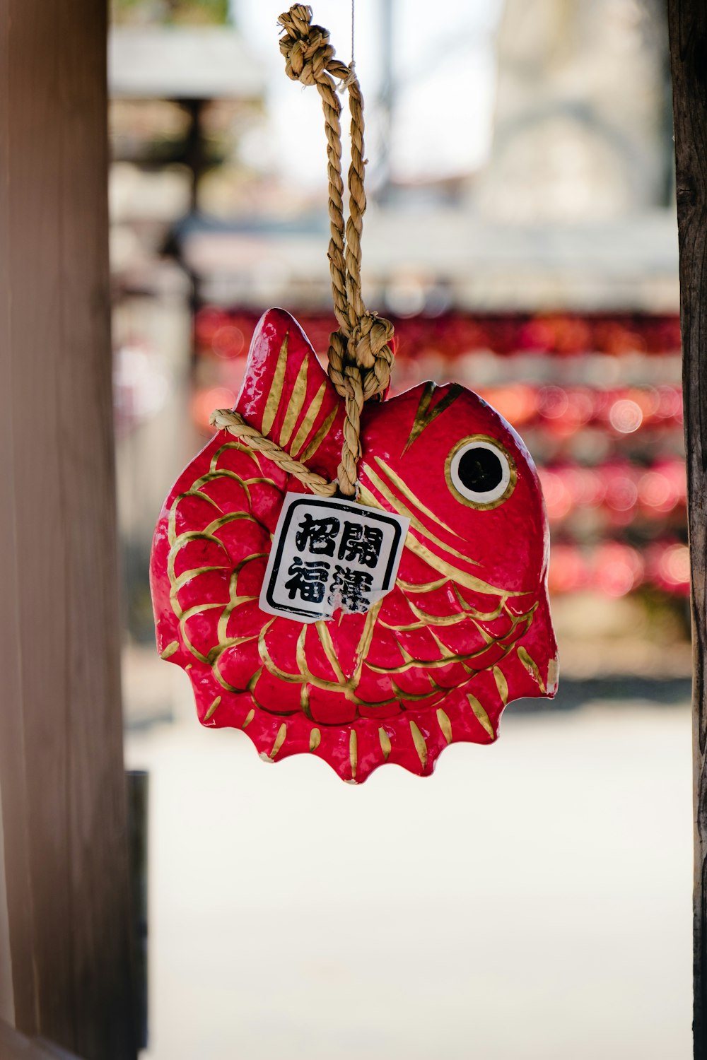 a red fish hanging from a wooden pole
