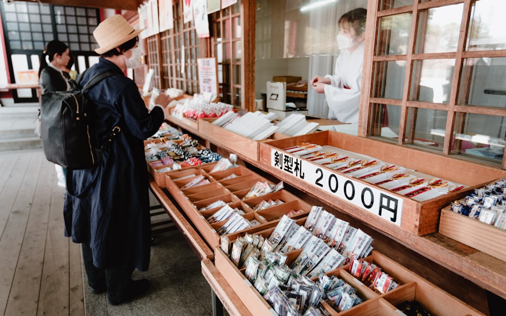 a woman standing in front of a store filled with boxes of food