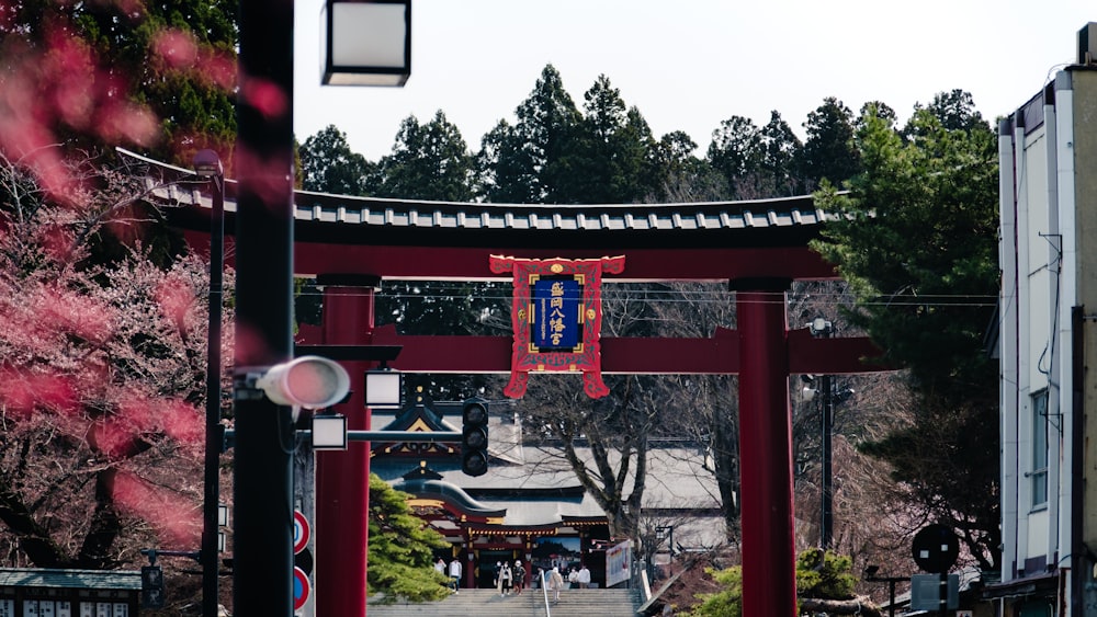 a red gate with a blue and white sign hanging from it's side