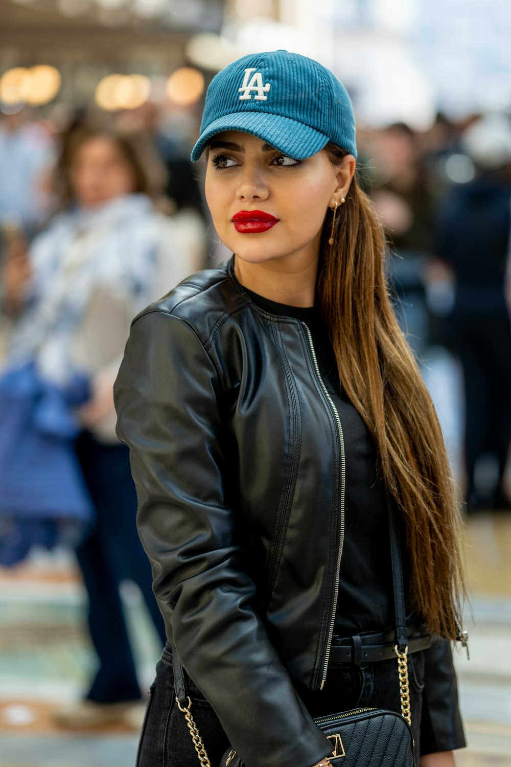 Una donna che indossa una giacca di pelle nera e un cappello blu