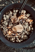 Close-up of a sizzling grill with mixed seafood and meats cooking over open flames.