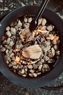 Close-up of a sizzling seafood grill with fish and prawns cooking over hot coals.