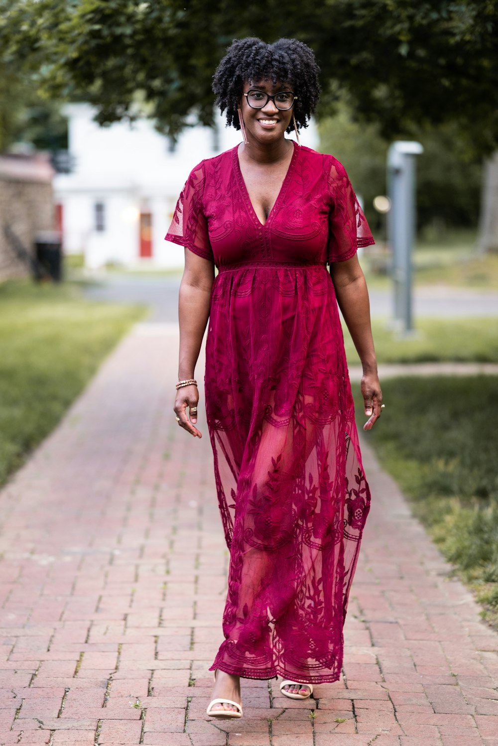 Foto Una mujer con un vestido rojo caminando por una acera – Imagen Persona  gratis en Unsplash