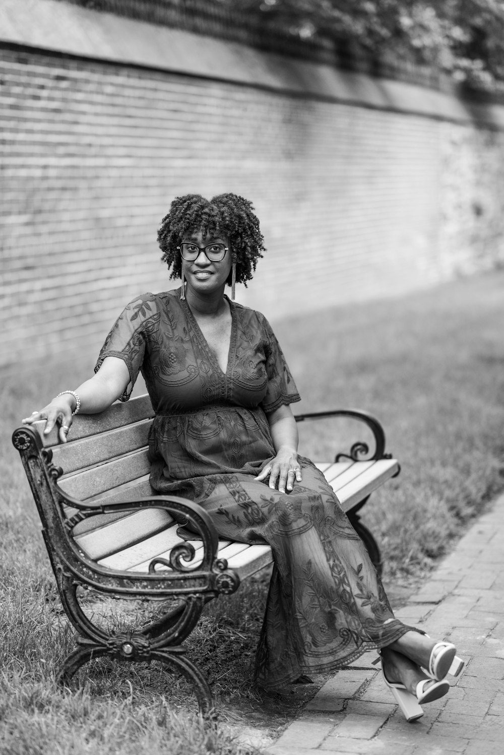 a black and white photo of a woman sitting on a bench