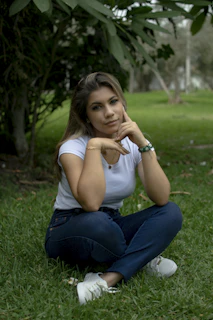A relaxed person sitting cross-legged on grass, eyes closed, embracing mindfulness.