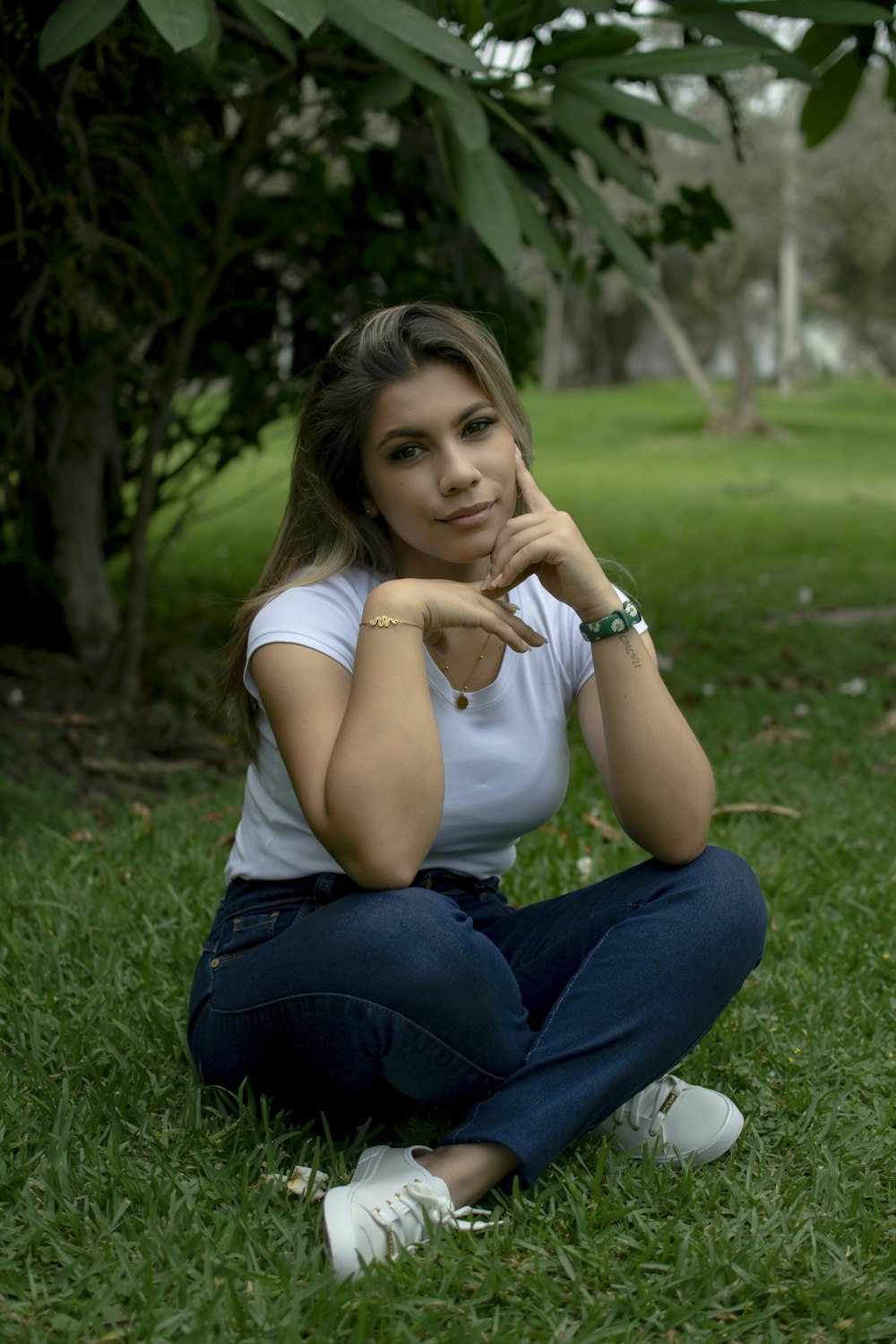 a woman sitting in the grass posing for a picture