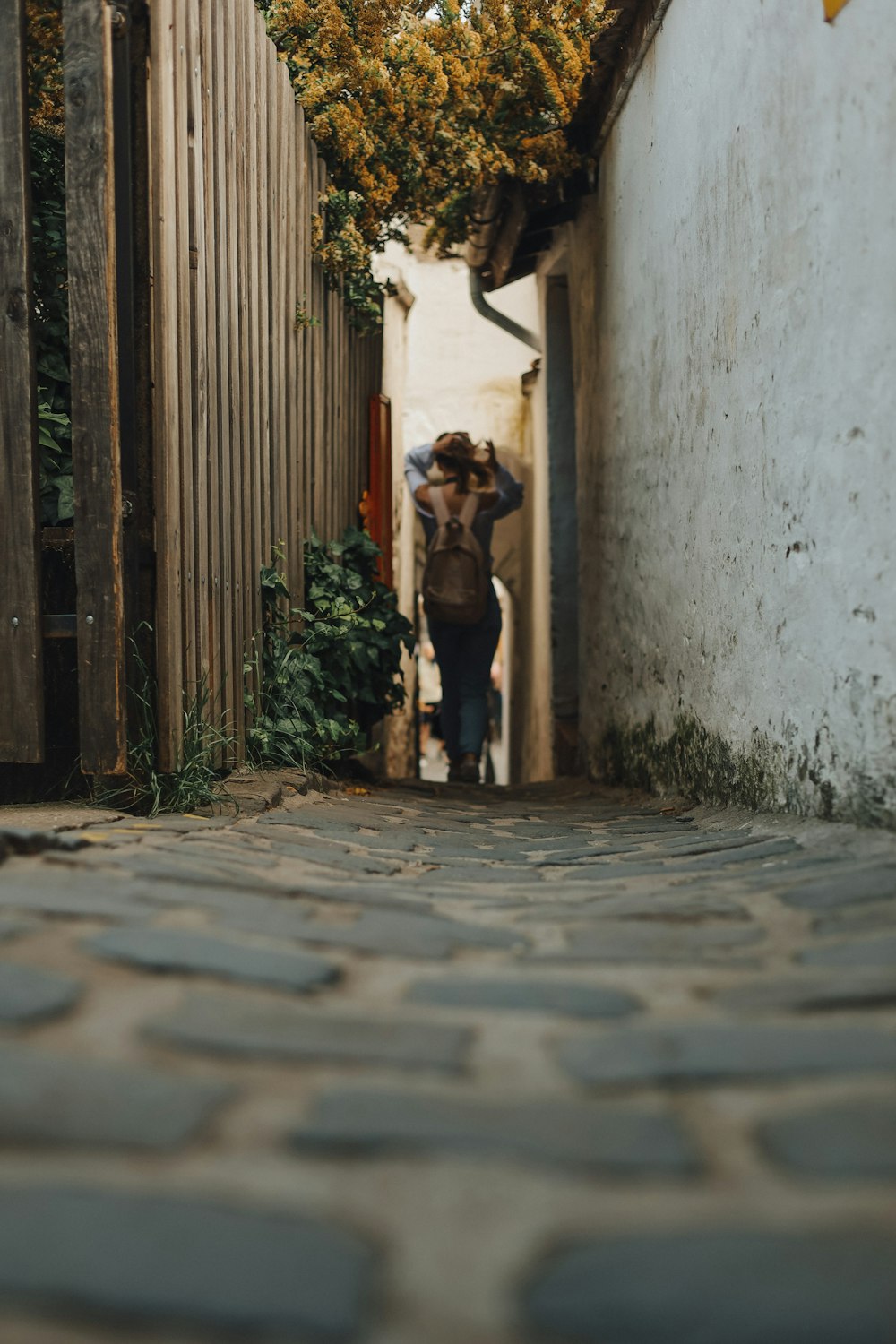 a person walking down a narrow alley way