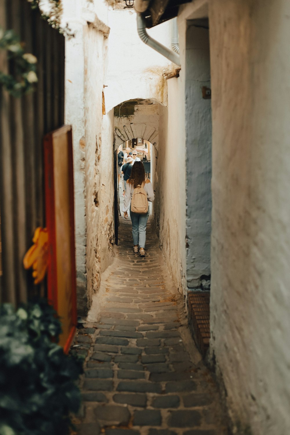 a person walking down a narrow alley way