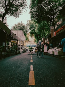Wide street view showing shops with parking space in front.