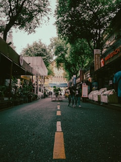 Wide street view showing shops with parking space in front.