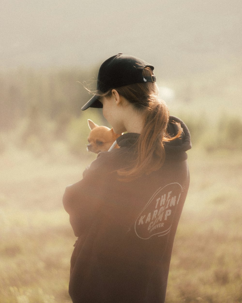 a woman holding a small dog in her arms