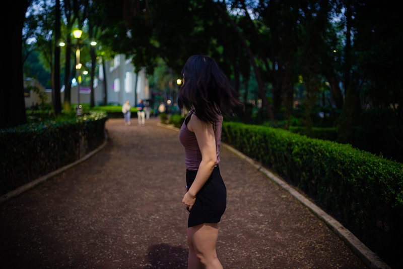 a woman in a short dress walking down a path