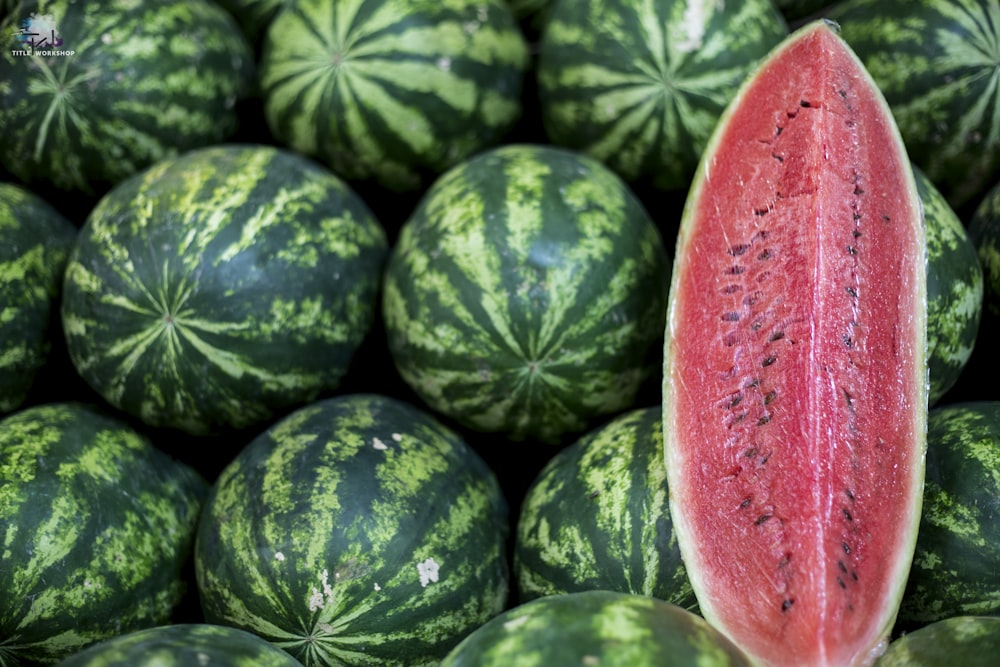 a close up of a watermelon in a pile of other watermelons