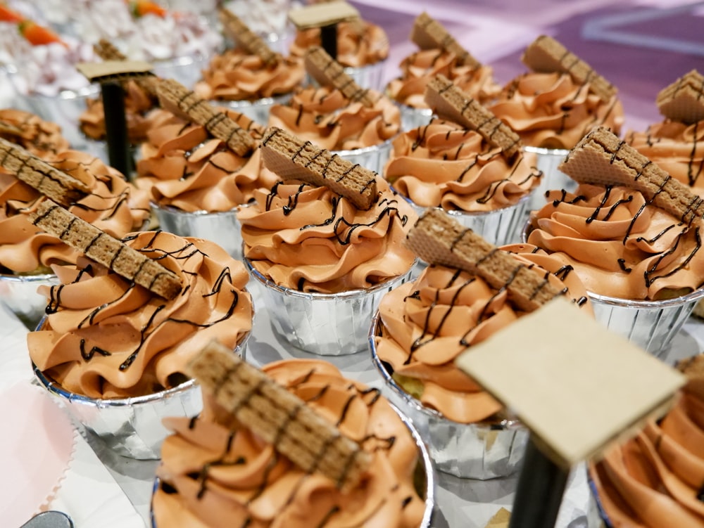 a table topped with lots of cupcakes covered in frosting