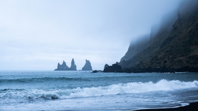 A misty morning scene of Iceland's rugged coastline at sunrise.
