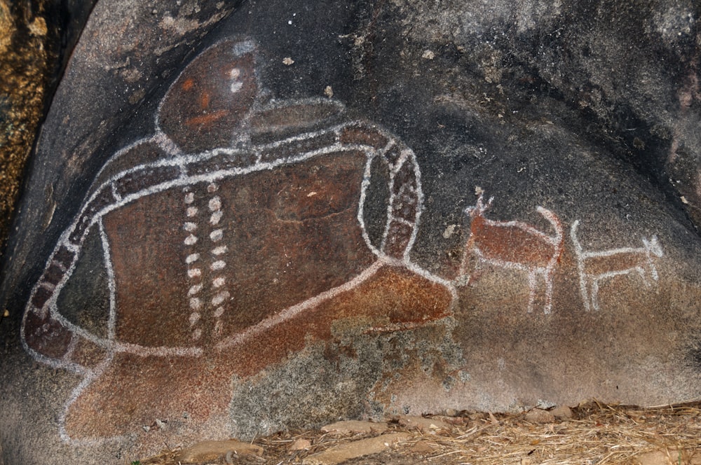 a rock with a painting of a man and a dog on it