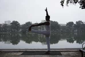 A serene yoga practitioner balancing gracefully on one leg during sunrise by the lake