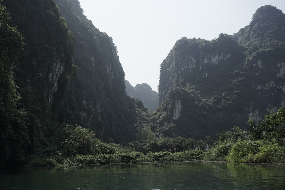 a body of water surrounded by mountains and greenery