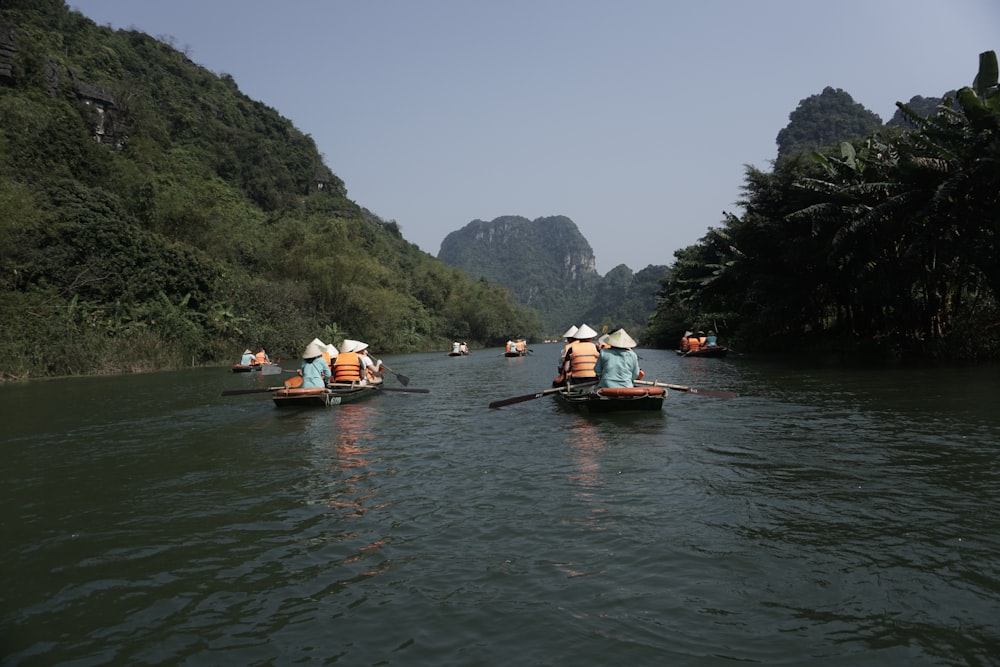 um grupo de pessoas em canoas remando por um rio