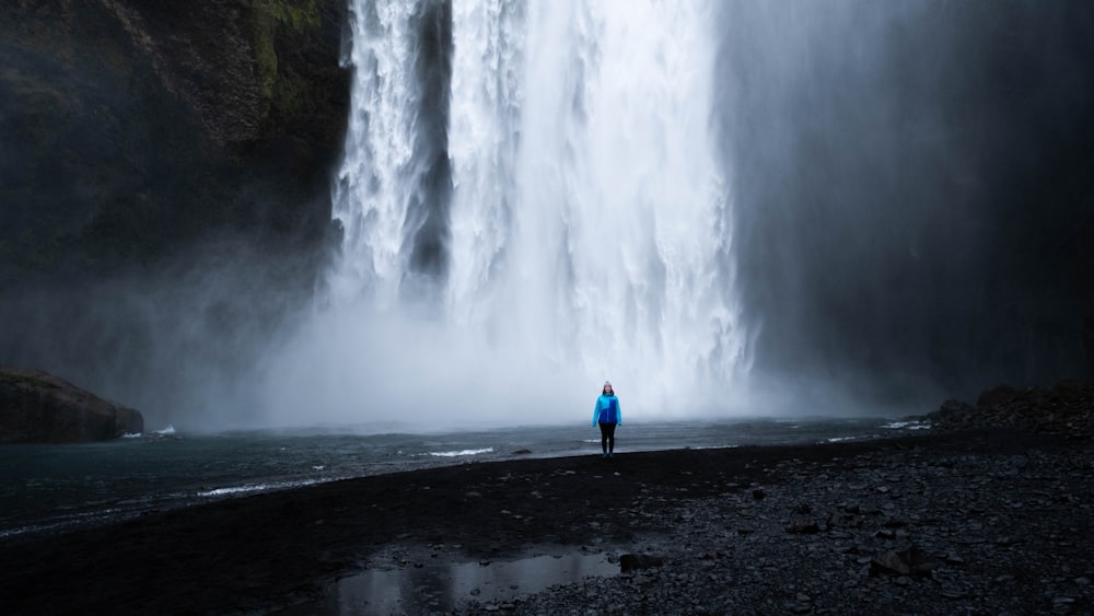 a person standing in front of a waterfall