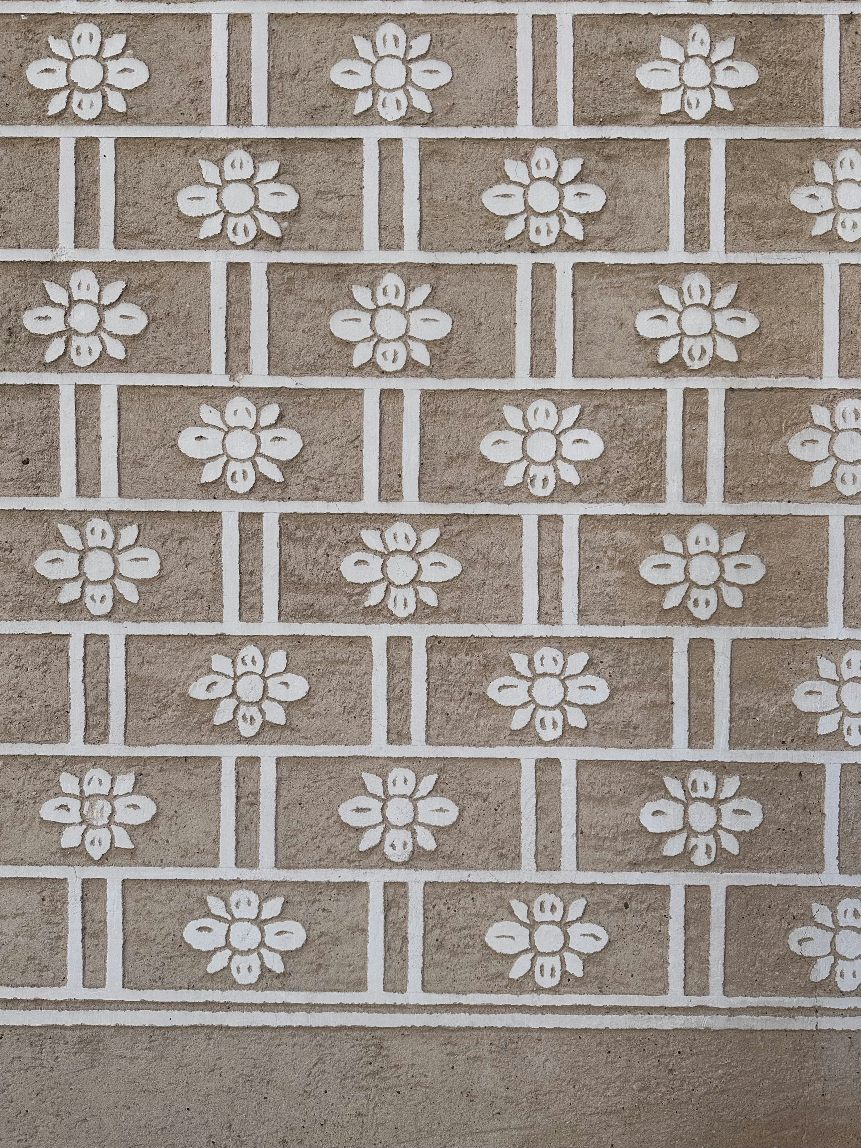 a brick wall with white flowers painted on it