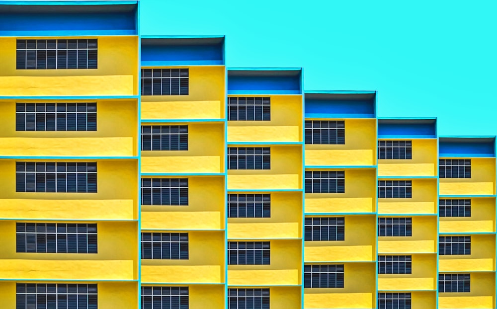 a yellow and blue building with a clock on it's side