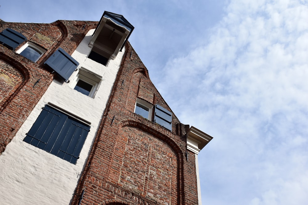 um edifício alto de tijolos com persianas e janelas azuis