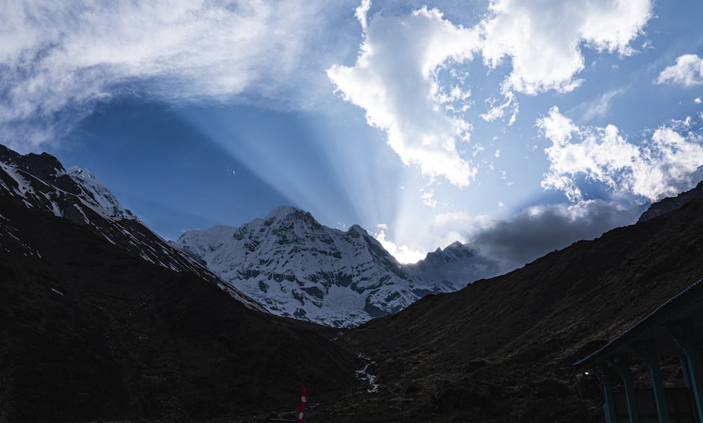 the sun is shining through the clouds in the mountains