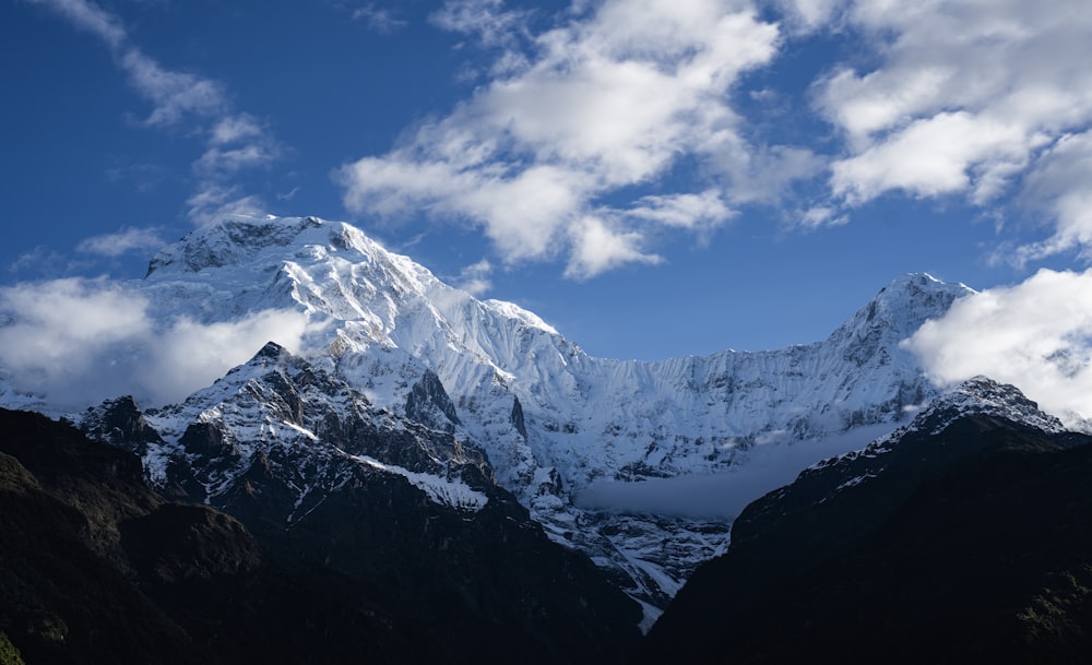 Una montagna coperta di neve sotto un cielo blu nuvoloso