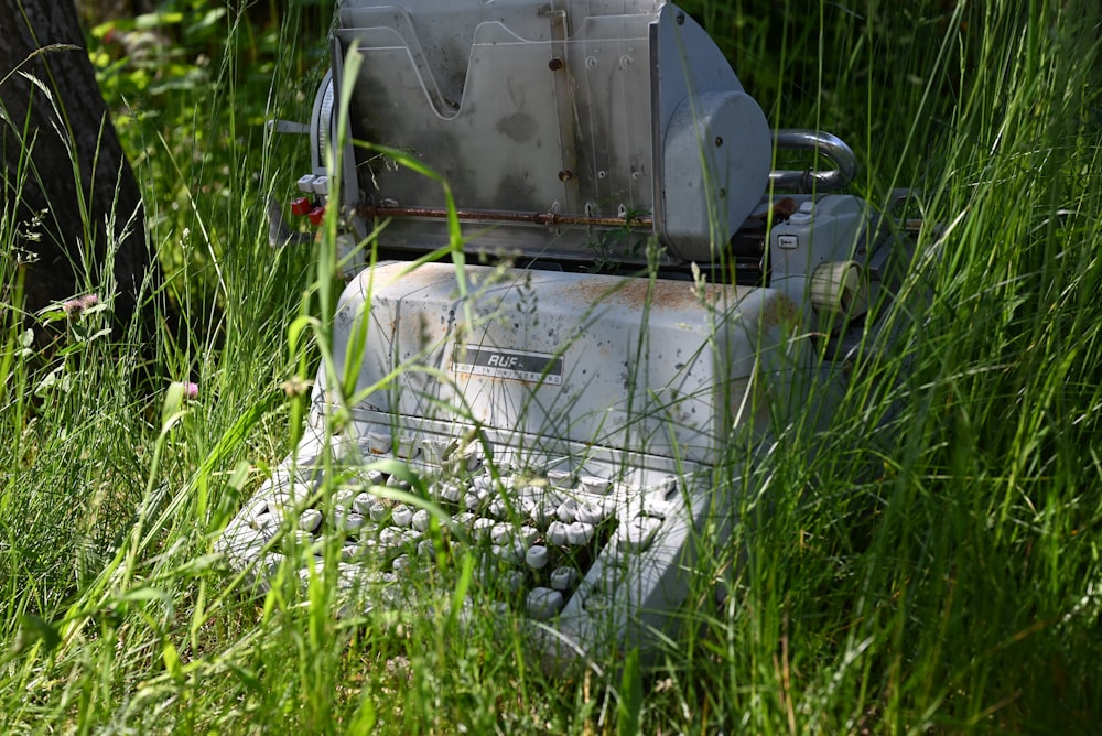 an old toilet sitting in a field of tall grass