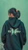 a woman wearing a green hoodie with a butterfly on it