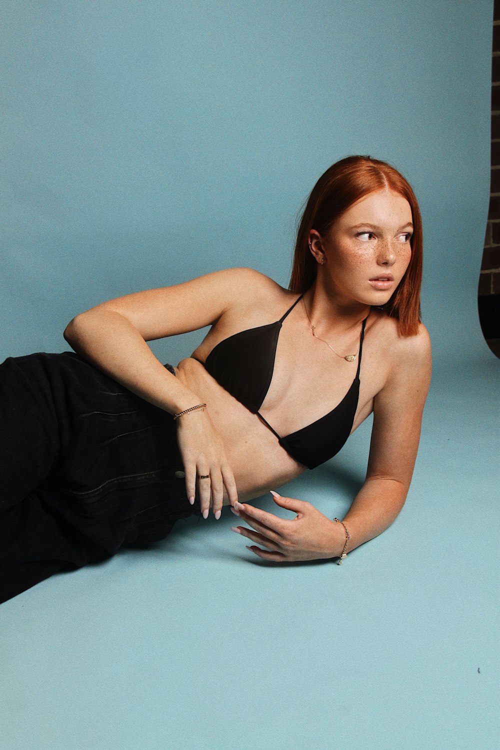 a woman in a black bikini laying on the ground