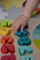 a child playing with wooden letters and numbers