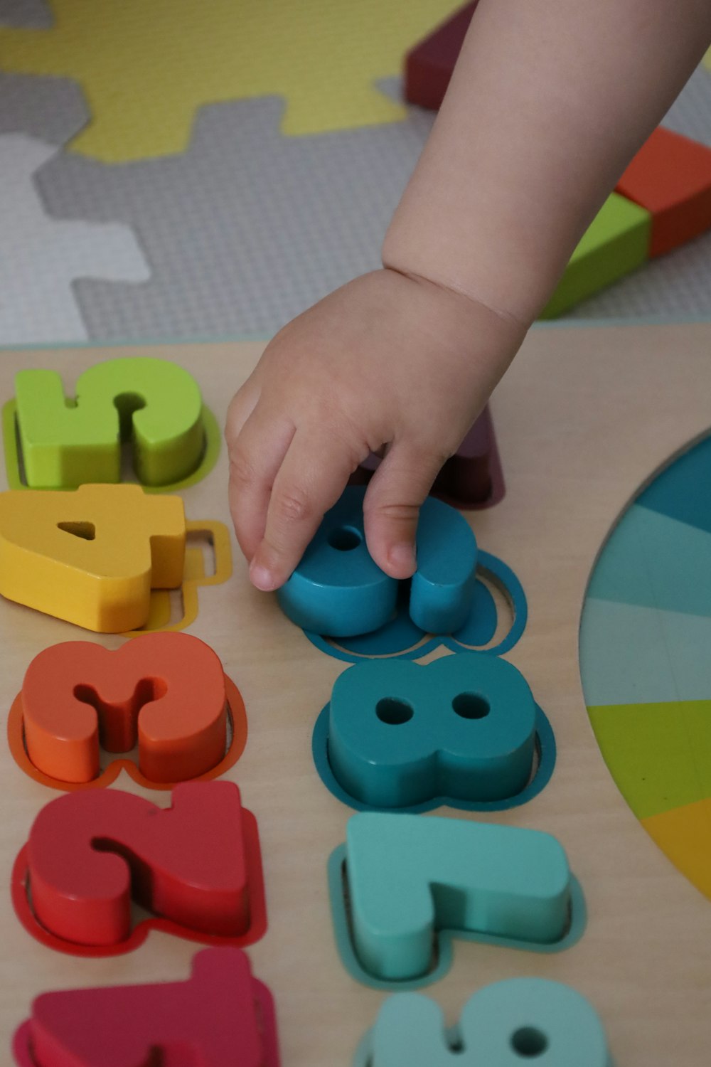 a child playing with wooden letters and numbers