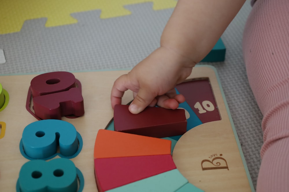 a child is playing with wooden toys on the floor