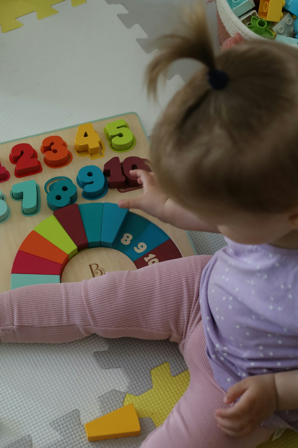 a little girl playing with a wooden toy