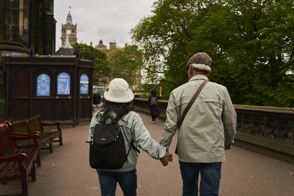 a man and a woman walking down a bridge holding hands