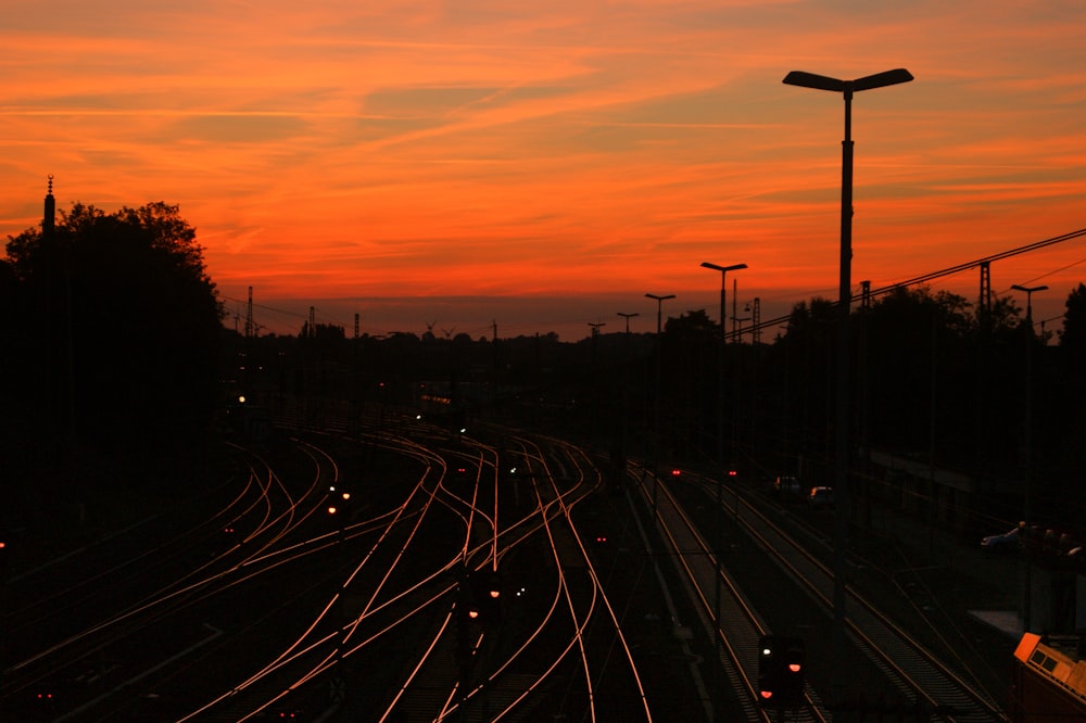 a train track with a sunset in the background