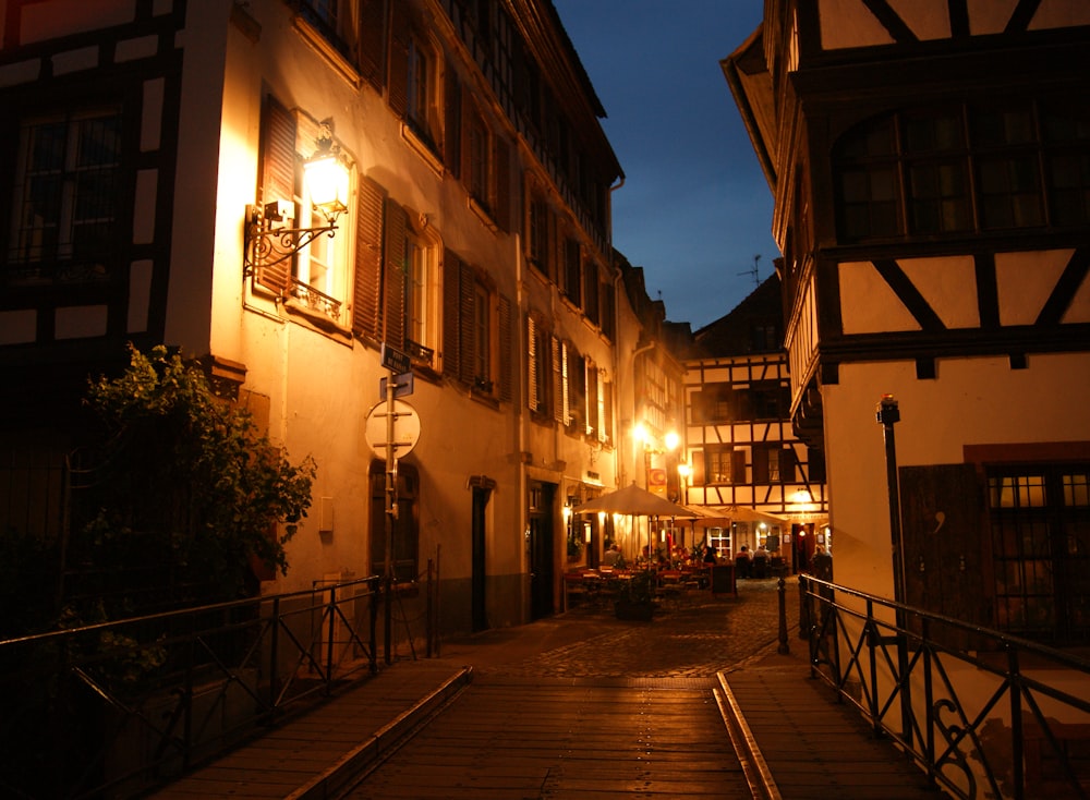 a cobblestone street at night with lights on