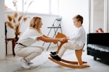a woman and a child playing on a rocking chair