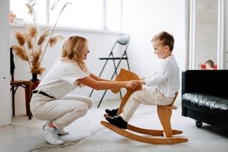 a woman and a child playing on a rocking chair