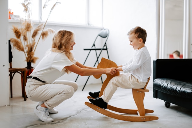 a woman and a child playing on a rocking chair