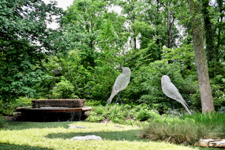 Close-up of a vibrant garden sculpture made from twisted recycled metal, set against lush greenery.
